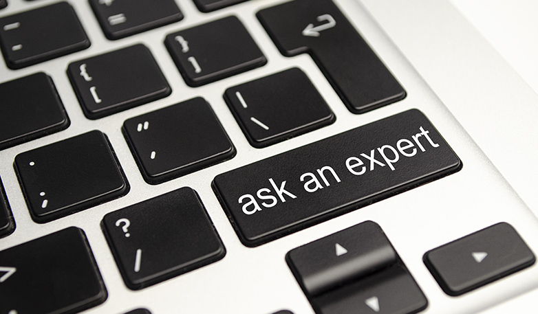 Close up button with the words ask an Expert, on a black keyboard. Creative background, copy space.
